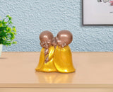 Resin Laughing Buddha monk sculpture: two monks in shiny yellow robes, heads touching