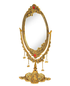 Oval tabletop mirror with gold filigree frame and red jewel details, dangling bead chains