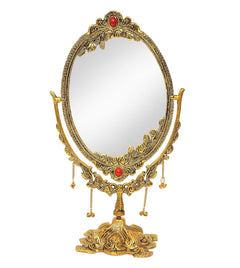 Standing oval tabletop mirror with gold-plated ornate frame, red jewel accents, hanging chains
