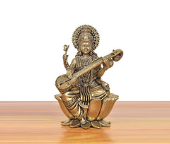 Brass Maa Saraswati statue seated on lotus with veena, side angle.