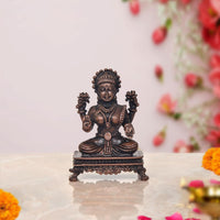 Copper Lakshmi seated on pedestal murti, four hands, dark bronze finish