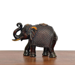 Dark bronze elephant figurine facing left, detailed head, ears, and textured body panel