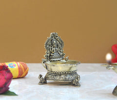 Brass Lakshmi oil lamp diya on four small feet, back view with canopy details