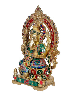 Brass Ganesha statue seated on lotus base, Kirtimuka frame, raised arms, multicolor