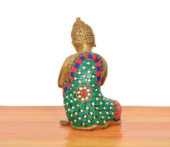 Back view of brass seated Buddha idol with multicolor patterned robe