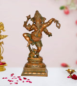 Dancing Ganesha brass statue with raised arms and decorative base