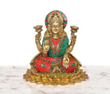 Brass Lakshmi idol on lotus base, teal-and-red attire with gold and gemstone-like trim