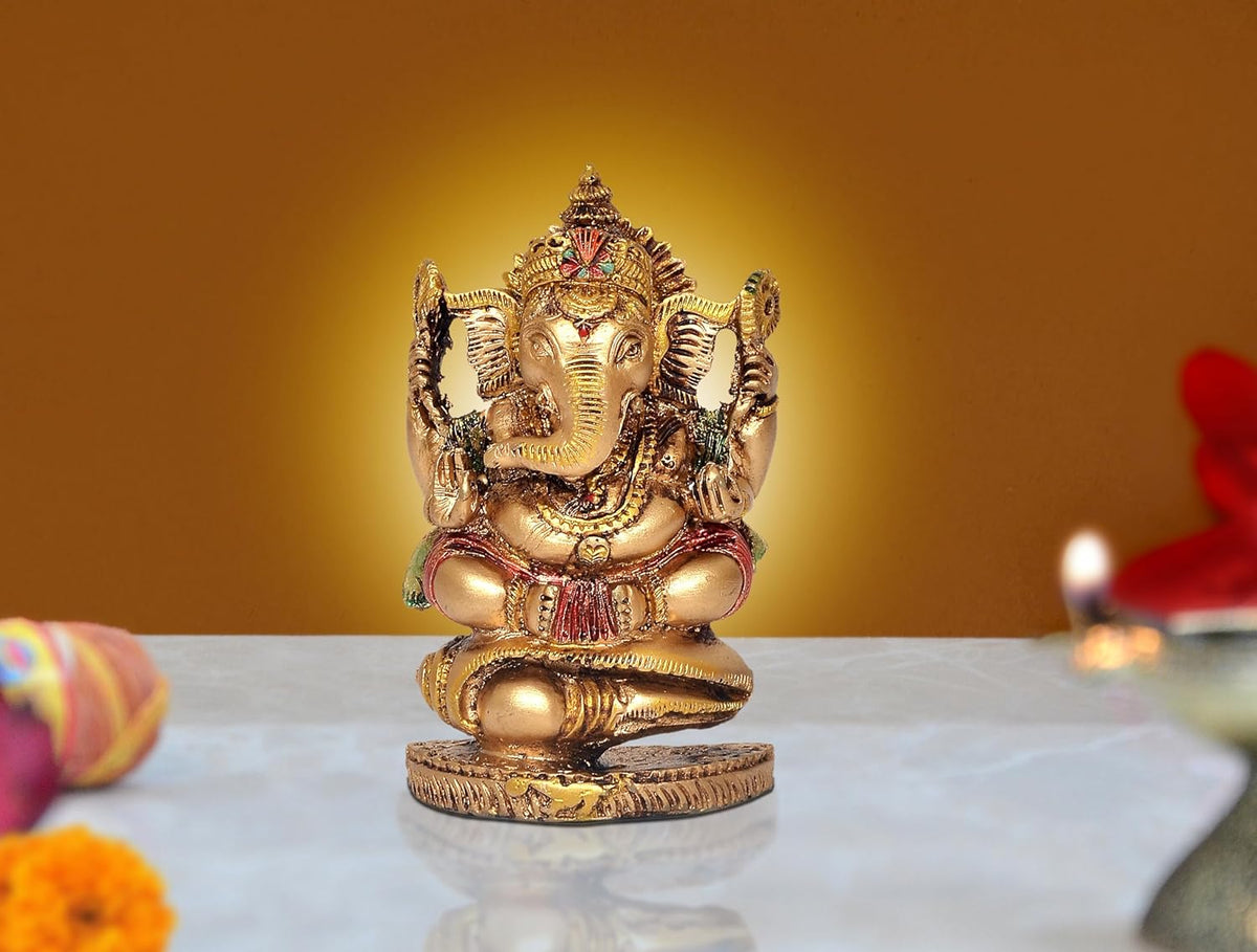 Resin Ganesha idol on shankh decorative base, gold tone with red accents, temple pooja showpiece