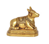 Brass Nandi bull statue close-up, profile view with decorative saddle and base