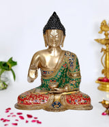Brass Buddha statue in meditating pose, gold face, green and red embroidered robe.