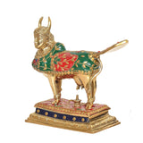 Brass Kamdhenu cow statue, side view with green-red patterned body and lamp on base