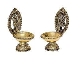 Brass diya oil lamps with arched frames, side view of Lakshmi and Ganesha