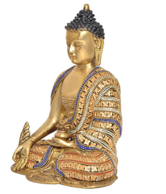 Side view of brass Buddha statue meditating, detailed beaded robe with blue accents