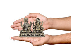 Brass Lakshmi and Ganesha idol held in hands, seated figures on base