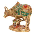 Side view brass Kamdhenu cow with calf, green and red floral ornaments on saddle