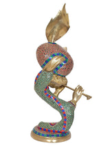 Brass Krishna flute idol side view, peacock crown, colorful robe, flute held forward
