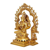 Side view of gold-tone Lakshmi statue seated on lotus with ornate back arch