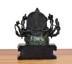 Brass Ganesha idol rear view with round halo disc and multi-armed attendants on pedestal
