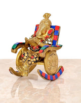 Side view of brass Ganesha statue on chair, reading, ornate beadwork and jewelry