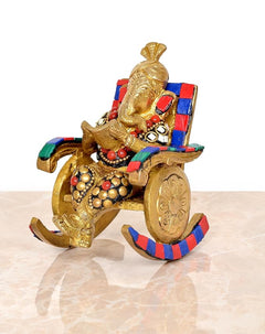 Side view of brass Ganesha statue on chair, reading, ornate beadwork and jewelry