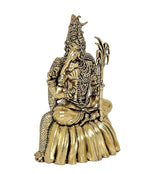 Gold tone brass goddess idol, seated with sculpted crown, attendants, and ornate detailing