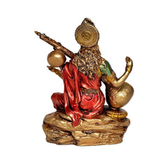 Resin Mata Saraswati idol from back view, red robe over gold base, veena and crown