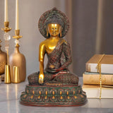 Brass Buddha statue meditating with halo, patterned robe, one hand mudra