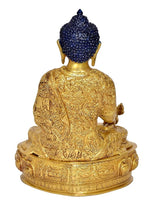 Back/angled view of seated gold Buddha statue idol with blue crown on decorative base