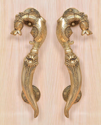 Ornate golden brass door handle pair with circular backplates and curled decorative ends