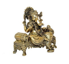 Side view brass Ganesha statue seated on ornate throne, decorative headdress