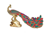 Brass peacock decor with spread fan tail in red, teal, and blue plus patterned base