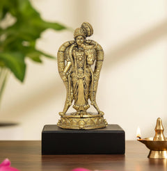 Golden seated deity idol with crown, hands in blessing pose, on lotus base