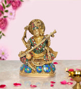 Seated Saraswati idol holding a veena, gold finish with multicolour jewel details