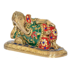 Side view of brass reclining Ganesha statue with green panel and red jeweled detailing