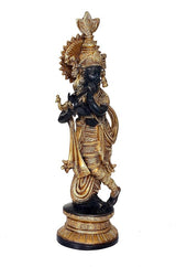 Krishna idol statue playing flute, gold ornate headdress and draped outfit, dark pedestal base