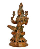 Lakshmi idol brass-tone seated with two legs folded, three hands raised holding lamps, side view