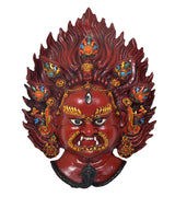 Close-up red resin Mahakal wall mask with golden face details, blue accents, flame hair