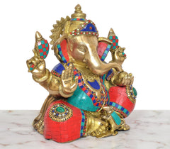 Brass Ganpati Bappa idol angled view, blue, red, and teal mosaic pattern on robe