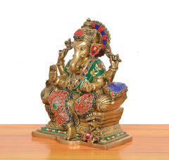 Side view of brass Ganesha statue seated on singhasan with multicolor beaded ornaments