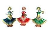 Three iron folk musician figurines with red, green, and teal skirts and brass instruments