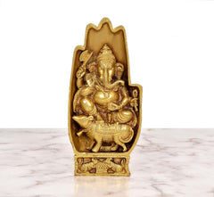 Golden brass Ganesha statue, frontal view, blessing pose and ornate relief on base.