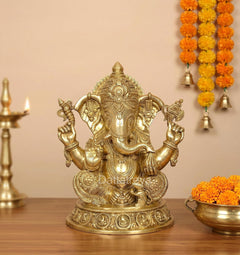 Golden brass Ganesha statue, seated with four arms and ornate crown