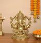 Golden brass Ganesha statue, seated with four arms and ornate crown