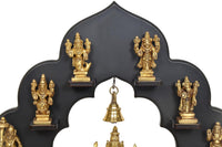 Close-up of brass Dashavatara idol frame with golden statues and hanging bell