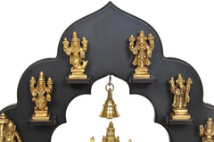 Close-up of brass Dashavatara idol frame with golden statues and hanging bell