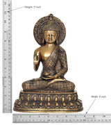 Brass Buddha statue with dhyan mudra; height 11 in, width 8 in shown on ruler