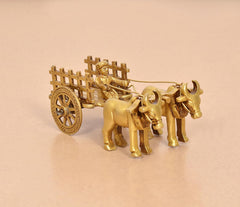 Brass vintage bullock cart showpiece, front three-quarter view with driver and wheel