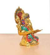 Metal Ganesha idol holding a scroll, colorful crown, teal-and-red detailed clothing