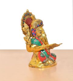 Metal Ganesha idol holding a scroll, colorful crown, teal-and-red detailed clothing