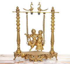 Brass Radha-Krishna idol on swing frame with hanging chains and ornate base